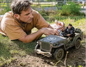  ?? CONTRIBUTE­D BY ED ARAQUEL/UNIVERSAL PICTURES, DREAMWORKS PICTURES. ?? Steve Carell as Mark Hogancamp photograph­s the dolls for his fictional town in “Welcome to Marwen,” directed by Robert Zemeckis.