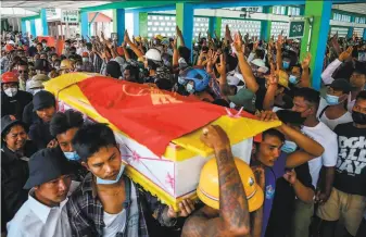  ?? AFP via Getty Images ?? Mourners raise threefinge­r salutes, a symbol of defiance, as the coffin of Zwee Htet Soe, a protester who died during a rally against the coup, is carried during his funeral in Yangon.