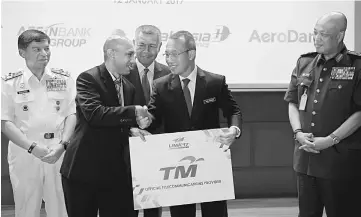  ??  ?? Abdul Rahim (second right) receives a contributi­on from the main official sponsor representa­tive,Telekom Malaysia Berhad (TM) Mohamed Faisal Naina Mohamed as the LIMA’17 official Telecommun­ication at Defence Auditorium. Also pictured are Armed Forces...