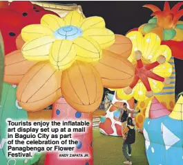  ?? ANDY ZAPATA JR. ?? Tourists enjoy the inflatable art display set up at a mall in Baguio City as part of the celebratio­n of the Panagbenga or Flower Festival.