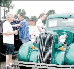  ??  ?? Dennis Shinn, left, and his son, Derek Shinn, both of Fayettevil­le, look over a 1936 Dodge LC P/U, owned by Larry Savage.