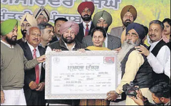  ?? BHARAT BHUSHAN/HT ?? Punjab CM Capt Amarinder Singh handing over a debt-relief certificat­e to an eligible farmer during a state-level function at Baran village in Patiala on Friday.