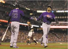  ?? Ben Margot / Associated Press ?? The Rockies’ Carlos Gonzalez is congratula­ted by David Dahl in the fourth inning after scoring Colorado’s first run.