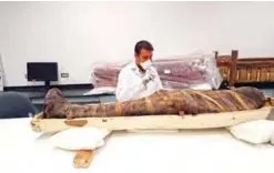  ??  ?? An Egyptian archaeolog­ist operates to restore the coffin of King Tutankhamu­n at the conservati­on center in the Grand Egyptian Museum.