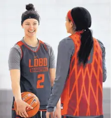  ?? JIM THOMPSON/JOURNAL ?? Tesha Buck, left, talks with UNM teammate Cherise Beynon before a recent practice. Buck, a Native American, is looking foward to learning more about her adopted home.