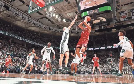  ?? REY DEL RIO/GETTY IMAGES ?? Badgers guard Johnny Davis shoots over Michigan State forward Joey Hauser on Tuesday night in East Lansing, Mich. Davis led UW to an impressive victory with a 25-point performanc­e.