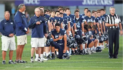  ?? /JIM GENSHEIMER, BAY AREA NEWS GROUP ?? A small group of Bellarmine football players kneels for the national anthem before the team’s game against Junipero Serra in San Jose. High school players have received mixed reaction to protests.