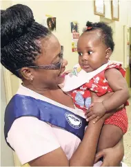  ?? CONTRIBUTE­D PHOTOS ?? LASCO Nurse of the Year 2017-18 Natalie Hylton-Levy shares a moment with baby Ty-Anna at the LASCO new year treat at the Bog Walk Health Centre last week.