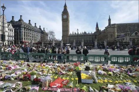  ?? AP PHOTO ?? People look at tributes Saturday in Parliament Square, London laid out for the victims of the Westminste­r attack on Wednesday.