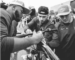  ?? ERIC DESALVO/UCF ATHLETICS ?? UCF football players work to assemble bikes for kids in the Tampa area ahead of the Gasparilla Bowl.