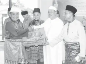  ??  ?? PENGERUSI Masjid Nurul Ikhwan Hj Madusup Brahim menerima sumbangan kurma daripada Hajiji, diperhatik­an oleh Hj Murneh Lamsari (kanan).