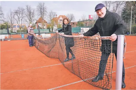  ?? RP-FOTO: ACHIM BLAZY ?? Vorsitzend­er Matthias Kreisel (vorne) zieht mit Jana Müller (Beisitzeri­n Sport) und den Platzwarte­n die Netze auf.