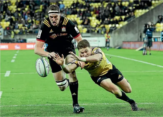  ?? PHOTOS: PHOTOSPORT ?? Hurricanes first five-eighth Beauden Barrett beats Chiefs lock and fellow All Black Brodie Retallick to score a crucial try in the Super Rugby match in Wellington last night.