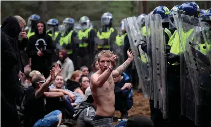  ??  ?? A reveller puts his hands up in front of riot police at the scene of a rave in Thetford forest, Norfolk. Photograph: Toby Melville/Reuters