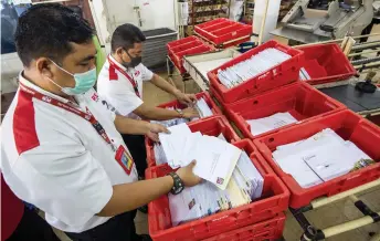  ?? Photo — Bernama ?? Osman (left) and a staff sort greeting cards at the Mail Processing Centre of Kota Bharu Post Office.