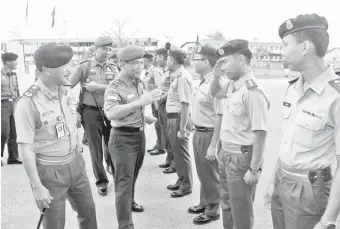  ??  ?? WIDODO (dua kiri) diiringi Bustaman (kiri) menerima tabik hormat daripada anggota TDM yang menyambut ketibaanny­a di Markas 3 Briged di Kem Penrissen, Kuching.