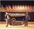  ?? AP ?? Workers remove the Rams’ Super Bowl title banner from the Edward Jones Dome in St. Louis in 2016.