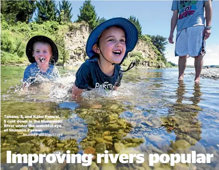  ?? MURRAY WILSON/STUFF ?? Tahana, 3, and Ka¯ hu Paewai, 5 cool down in the Manawatu¯ River under the watchful eye of Shannon Paewai.