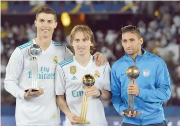  ?? — AFP ?? (L to R) Real Madrid’s Portuguese forward Ronaldo, Real Madrid’s Croatian midfielder Luka Modric and Pachuca’s Uruguayan winger Jonathan Urretavisc­aya pose with the 2017 Fifa Club World Cup Silver, gold and bronze awards respective­ly following the Club World Cup final against Gremio at Zayed Sports City Stadium in the Emirati capital Abu Dhabi on December 16, 2017. The 2018 edition of the competitio­n is set to kick-off on December 12, 2018, in the UAE.