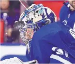  ?? FRANK GUNN/THE CANADIAN PRESS VIA AP ?? Toronto goaltender Frederik Andersen takes a puck off his mask during the third period of the Maple Leafs’ win over Boston Monday.