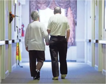  ?? MATT ROURKE, AP ?? Decima Assise, who has Alzheimer’s disease, walks with Harry Lomping at the Easton Home in Easton, Pa. Dementia in people older than age 65 fell from 11.6% in 2000 to 8.8% in 2012.