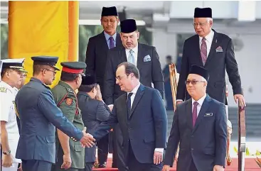  ?? — RAJA FAISAL HISHAN/ The Star ?? Royal presence: Yang di-Pertuan Agong Sultan Muhammad V and Najib accompanin­g Hollande as he greets a military officer during the state welcoming ceremony at Parliament square.