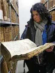  ??  ?? Grit Baum vom Staatsarch­iv Altenburg mit einem Grundbuch aus dem . Jahrhunder­t