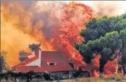  ?? AFP ?? A house is engulfed by a huge blaze during a wildfire in Kineta, near Athens, on Monday.