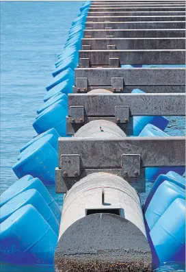  ?? CATHIE COWARD THE HAMILTON SPECTATOR ?? They may look like giant blue pool noodles, but these 1,200 plastic barrels are holding up the breakwater at the west harbour’s marina, a temporary solution after a severe April storm partially sunk the 300-metre-long structure.