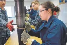  ?? Steven Senne, Associated Press file ?? Ensign Megan Stevenson of Raymond, Maine, trains at patching high-pressure pipe leads during a class at the Naval Submarine School in Groton, Conn. The Navy announced it will allow women to wear hairstyles other than buns, which don’t fit well under...