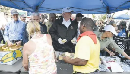  ?? Brendan Smialowski, AFP ?? Gov. Rick Scott, from left, Vice President Mike Pence and President Donald Trump serve food to people affected by Hurricane Irma on Thursday in Naples, Fla.