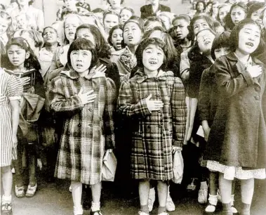  ?? DOROTHEA LANGE LIBRARY OF CONGRESS ?? In April 1942, children recite the Pledge of Allegiance at a public school in San Francisco. Some of them are evacuees of Japanese ancestry who will be housed in War Relocation Authority centers for the duration of World War II.