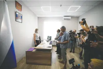  ?? Associated Press ?? A group of Ukrainians in Melitopol recite a Russian citizenshi­p oath surrounded by Russian and foreign journalist­s during a trip organized by the Russian Ministry of Defense on July 14.