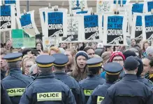  ??  ?? Police stop oil pipeline protesters from using a gate to enter Parliament Hill on Monday.