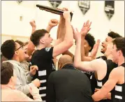  ?? MATTHEW B. MOWERY — MEDIANEWS GROUP ?? Bloomfield Hills Brother Rice players celebrate with the regional championsh­ip trophy. Rice led from start to finish in its Division 1regional finals matchup against Chippewa Valley at Troy High School on Thursday, winning 76-44 to claim its first regional title since 1984.