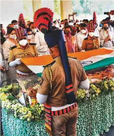  ?? AFP ?? Soldiers place the national flag on the casket containing the body of Rahul Bajaj during his last.