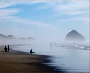  ?? ASSOCIATED PRESS FILE PHOTO ?? People walk on the beach at Tierra del Mar, Ore., on, Aug. 17.