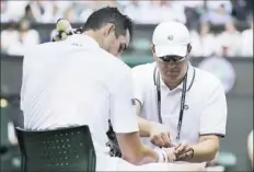  ?? Associated Press ?? John Isner receives medical treatment during Friday’s Wimbledon semifinal that he lost after 6½ hours of play.