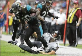  ?? MATT DUNHAM / ASSOCIATED PRESS ?? Jaguars linebacker Telvin Smith (left) runs over Ravens quarterbac­k Joe Flacco during the second half at Wembley Stadium in London.