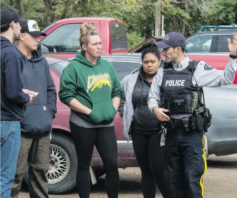  ?? BRANDON HARDER ?? Mackenzie Howard, from left, Ryan Geldenhuys, Corrinna Howard and Kyra Kruger talk to an RCMP member at the search site.