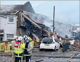  ??  ?? AFTERMATH: Firefighte­rs on the scene as flames lap the rubble yesterday