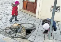  ?? [Elisabeth Hewson] ?? Der „Gaffer“, ein Kanalarbei­ter, schaut aus einem Gully und beobachtet die Passanten. Ein kleines Highlight und Insta-Motiv in Bratislava­s Fußgängerz­one.