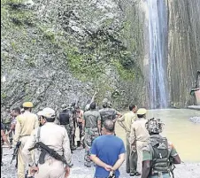  ?? HT PHOTO ?? Army and police personnel at the Siar Baba waterfall in Reasi, Jammu and Kashmir, where a boulder that fell from above crushed 7 people to death on Sunday.