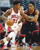  ?? The Associated Press ?? Chicago Bull Jimmy Butler, left, drives against Toronto Raptor DeMar DeRozan during an NBA game Saturday in Chicago. Butler scored 42 as the Bulls won 123-118 in overtime.