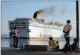  ?? PICTURE: AP ?? SETTING SAIL: Migrants watch as the Eleftherio­s Venizelos, with Syrian migrants on board, leaves the south-eastern Greek island of Kos yesterday.