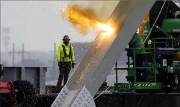  ?? Kaitlin Newman/The Baltimore Banner via AP ?? Workers are seen in the beginning stages of dismantlin­g the steel from the frame of the collapsed Francis Scott Key Bridge by using an exothermic cutting torch Thursday in Baltimore.