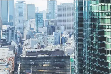  ??  ?? Office buildings are pictured at a business district in Tokyo. Boutique advisers specialisi­ng in micro-M&A for mostly family-run firms are enjoying a boom in Japan, as an ageing, shrinking population brings in the boundaries on the country’s small...