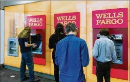  ?? DEVIN YALKIN / THE NEW YORK TIMES 2017 ?? Patrons wait to use Wells Fargo ATMs in New York. Friday’s $1 billion settlement covers issues in Wells Fargo’s auto-lending and mortgage units.