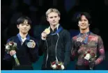  ?? ?? MONTREAL: Gold medalist Ilia Malinin of the United States (C) poses with silver medalist Yuma Kagiyama of Japan and bronze medalist Adam Siao Him Fa of France during the victory ceremony the men’s free program at the Internatio­nal Skating Union (ISU) World Figure Skating Championsh­ips in Montreal, Canada. — AFP