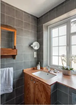  ??  ?? The master bathroom packs a lot into a small space. Wall-hung sanitarywa­re and large-format tiles on the walls and floor help to give the illusion of more room